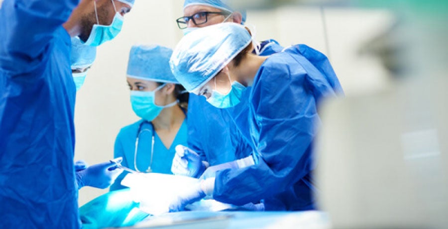 Surgeons and nurses performing operation in operating room